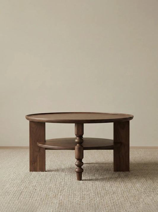 Isolated front view of the Walnutry Sylvan solid black walnut round coffee table with storage shelf on white background.