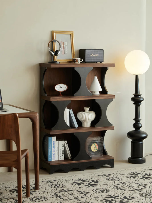 Sylvan geometric walnut shelf in a home office setting next to a floor lamp, demonstrating vertical storage functionality.