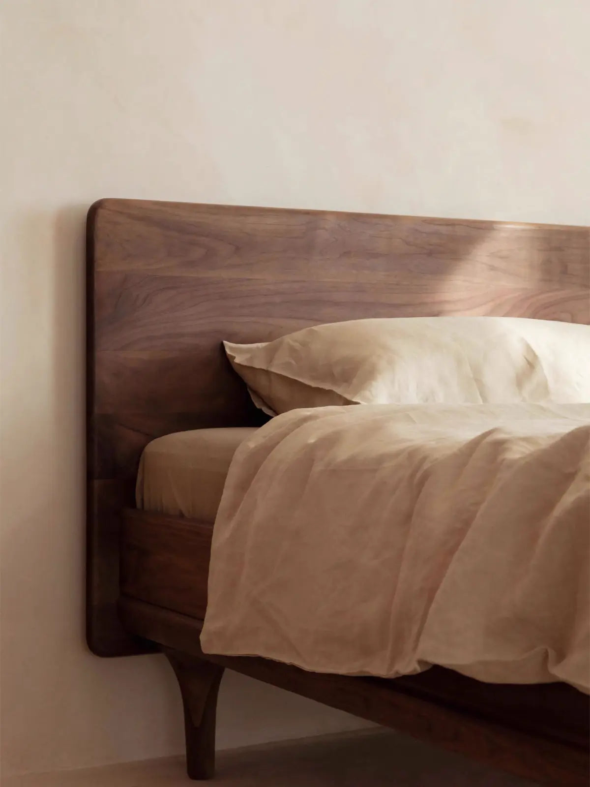 Close-up detail showing the natural premium wood grain texture of the solid walnut headboard on The Estate Bed Frame.