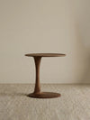 Profile view of The Orbit solid walnut side table against a neutral background, clearly showing the elegant tulip pedestal silhouette.