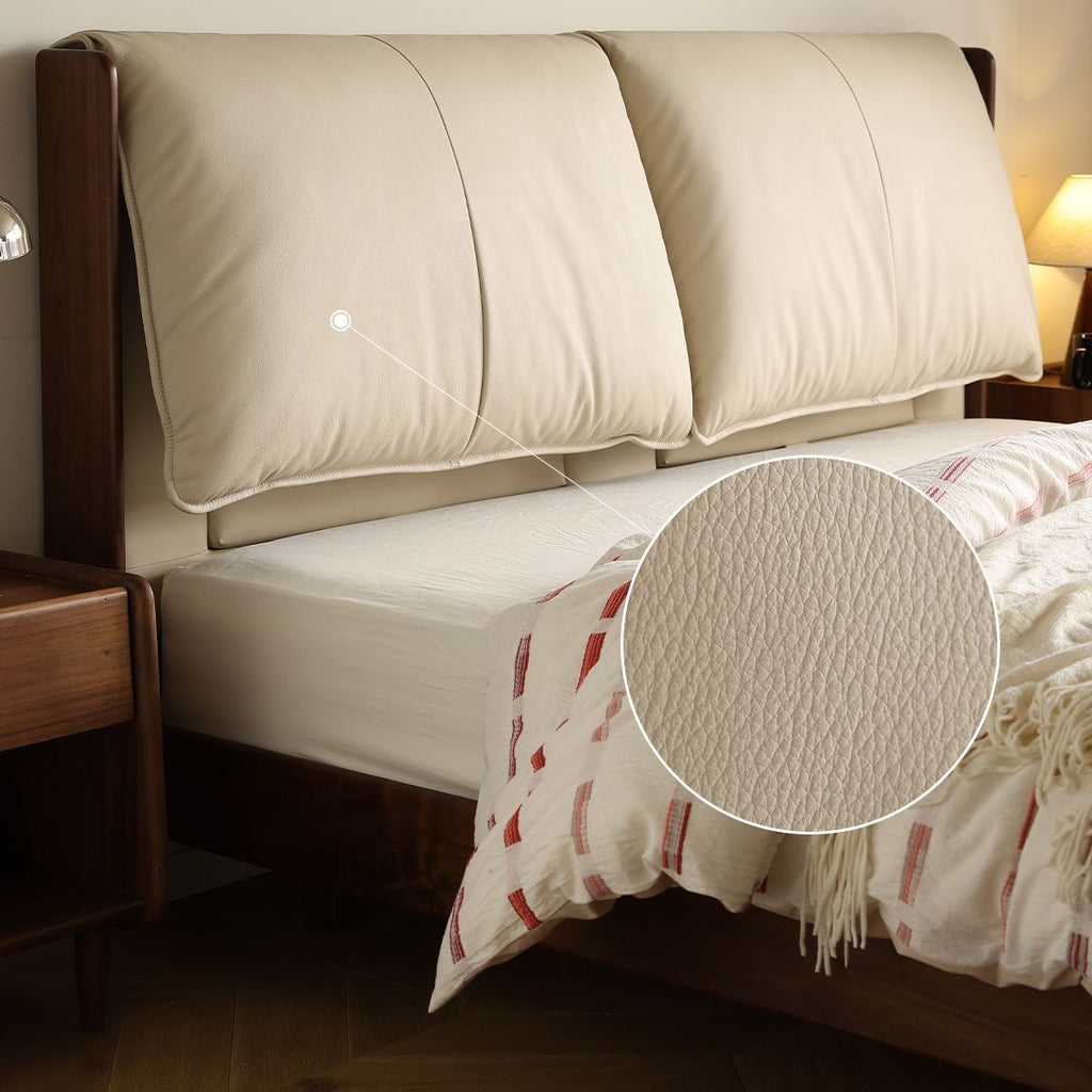 Cream top grain leather textured headboard cushions on wooden bed frame in cozy bedroom