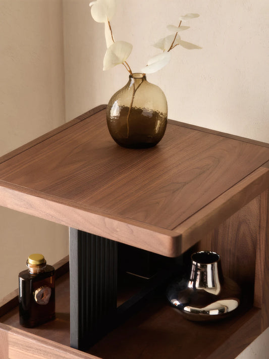 Top down view of the rotating bookshelf surface featuring natural walnut wood grain and minimalist vase decor.