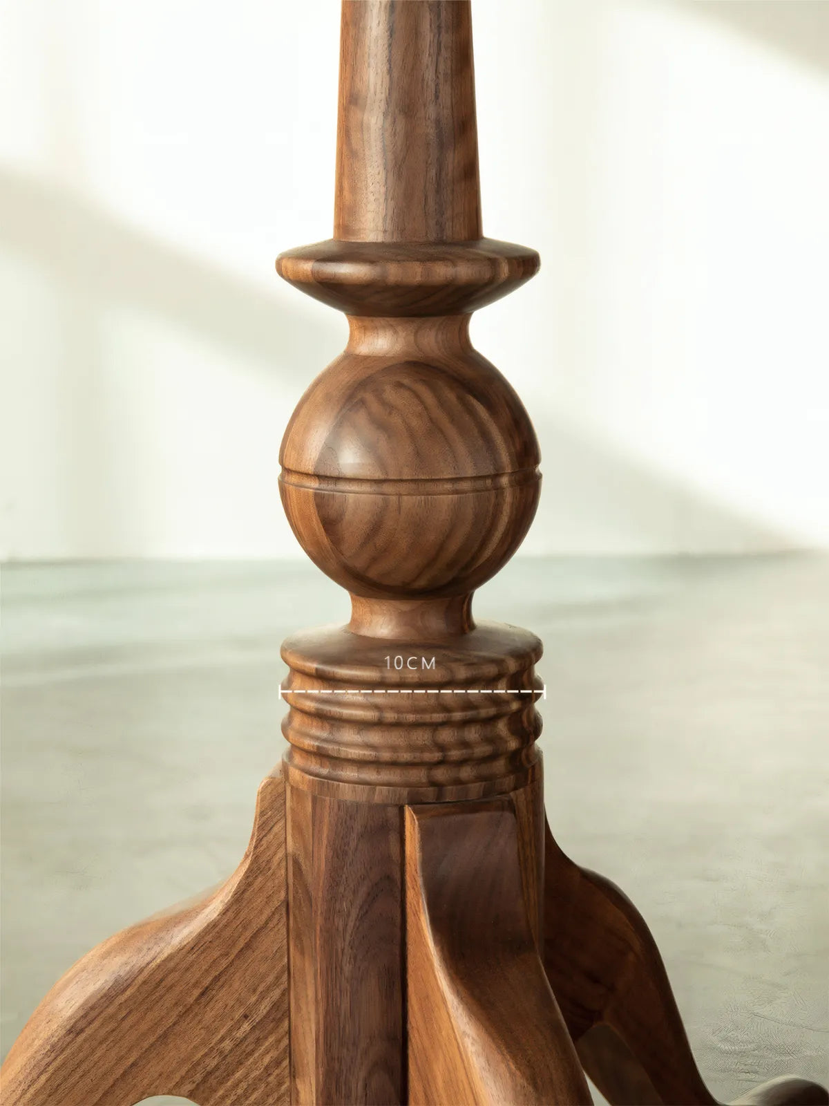 Close-up of the solid wood turned pedestal base showing craftsmanship and 10cm diameter specification.