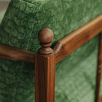 Close-up detail of the hand-turned wooden roman column spindles on the walnut sofa armrest.