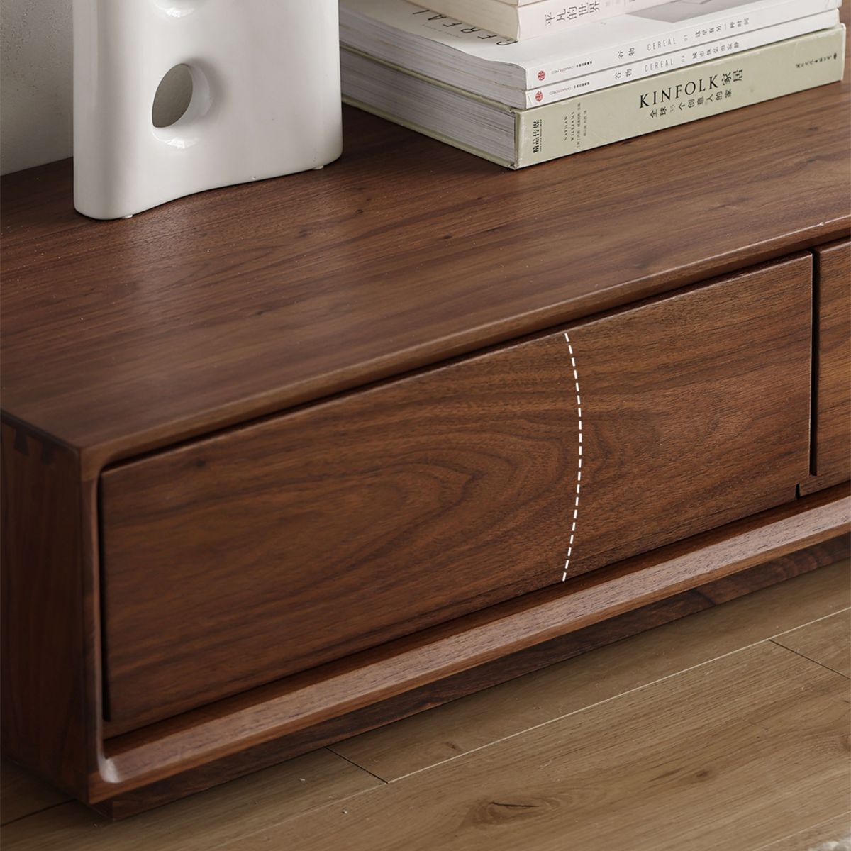 Close-up of solid North American black walnut ultra-low TV cabinet with natural oil finish and stacked books