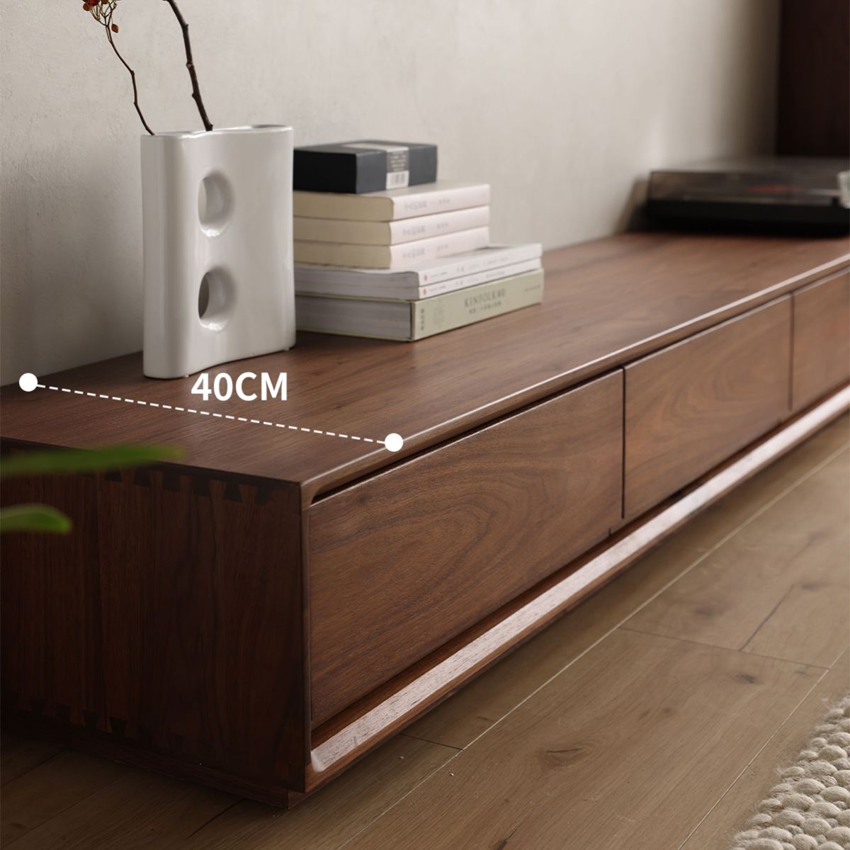 Side profile of ultra-low walnut wood TV cabinet with books, white ceramic vase, and 40cm depth
