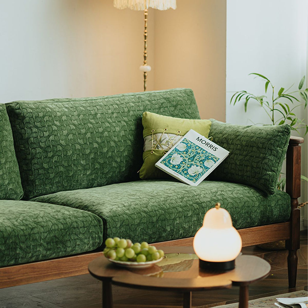 Vintage green patterned fabric couch with yellow pillow and Morris book in a cozy living room