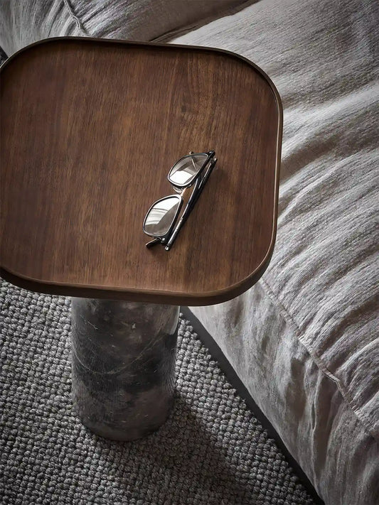 Cumberland walnut table used as a minimalist bedside table or small nightstand in a bedroom.