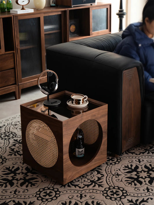 Walnutry Sylvan cat side table placed next to a black leather sofa in a mid-century modern living room
