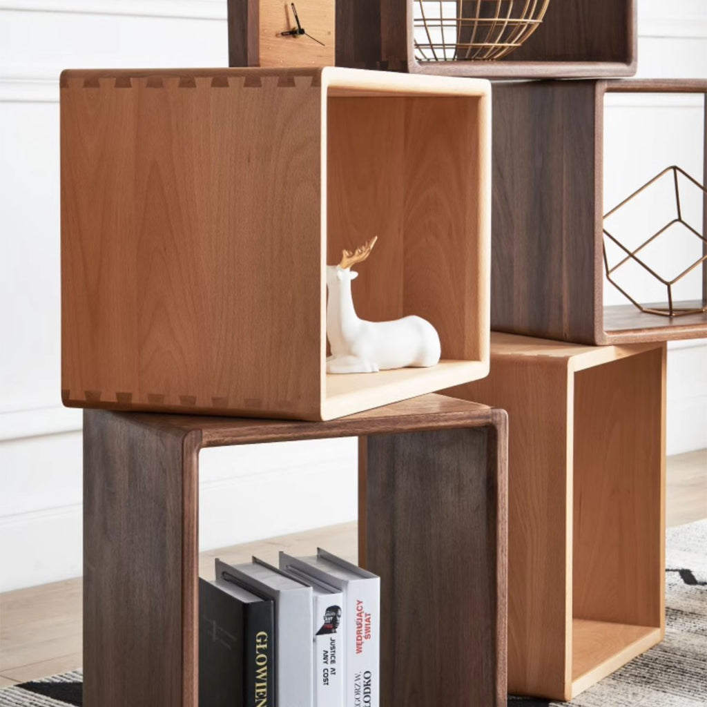 Stacked wooden cubes in walnut, cherry, and poplar finishes with decor including books, a white deer figurine, and metal wire ornaments