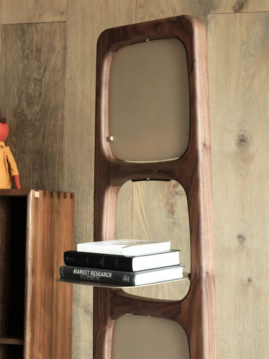 Close-up detail of the rounded shelf edges and structural aperture design of the solid walnut unit.