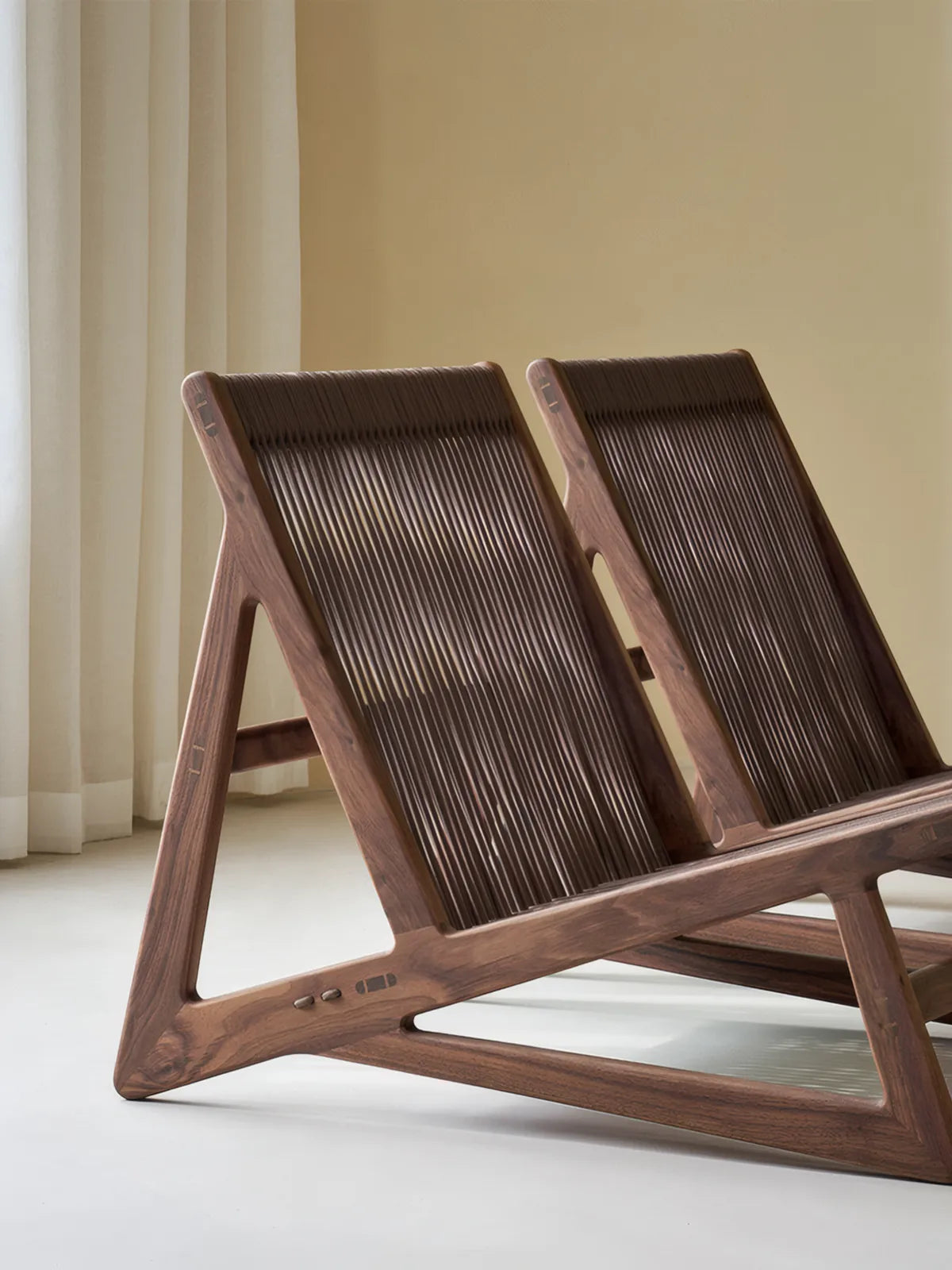 Rear view of two Suiseki chairs showing the sturdy A-frame construction and back weaving.
