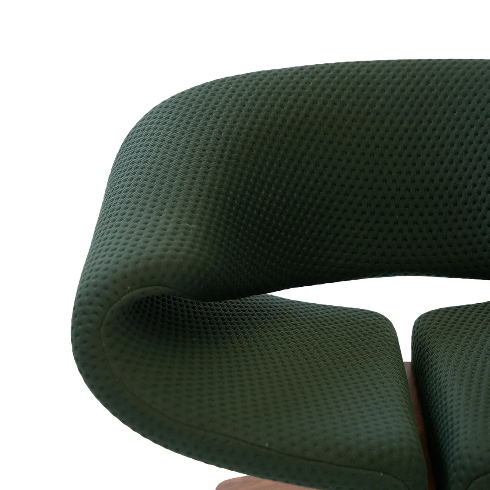 Close-up of green textured fabric sculptural lounge chair armrest with walnut wood frame detail
