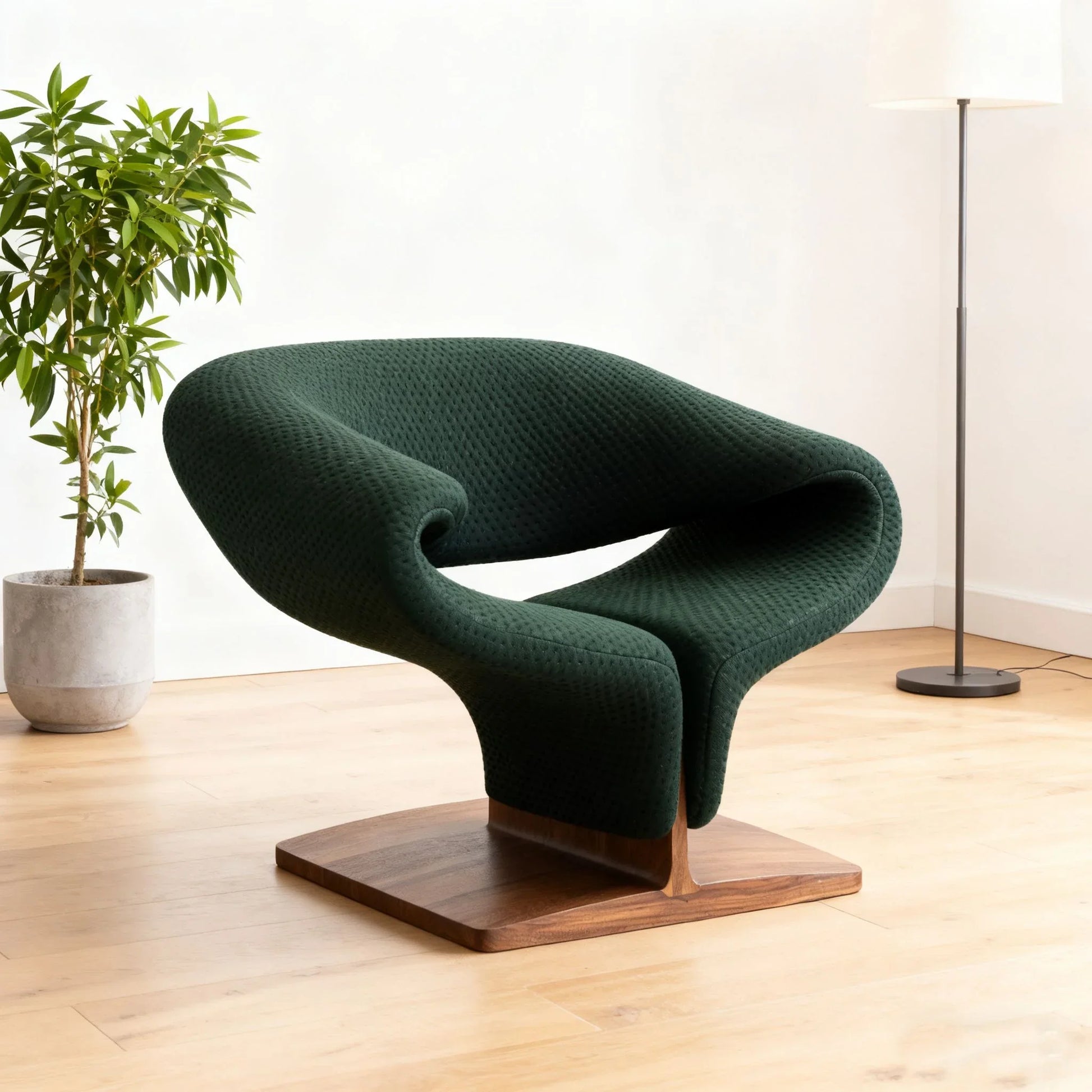Modern sculptural lounge chair with dark green fabric and solid walnut wood base in light wood floor room