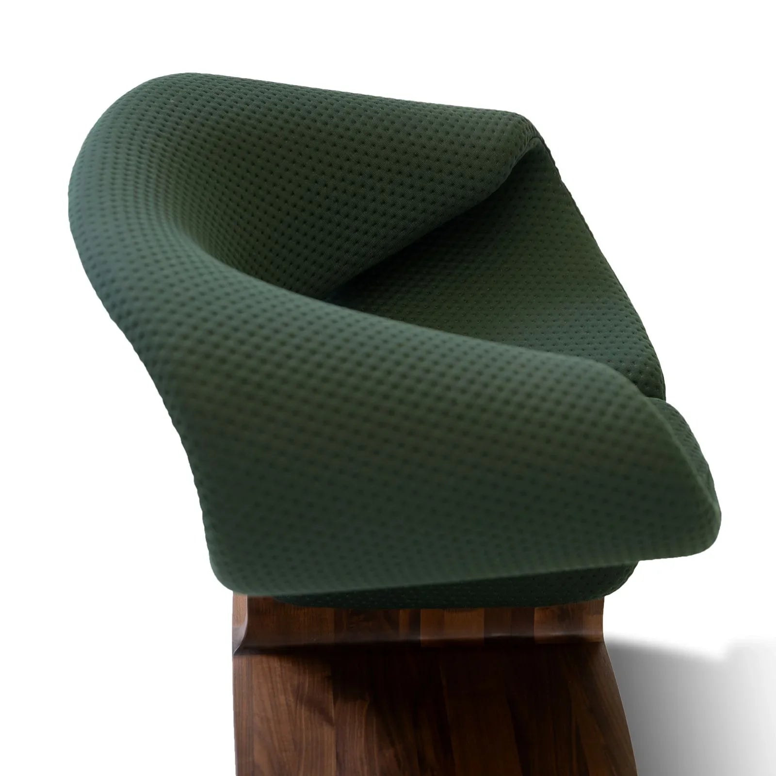 Top view of sculptural lounge chair with green textured fabric and solid walnut wood base