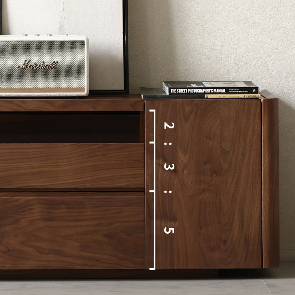 Close-up of walnut wood grain TV cabinet side with drawers, books, and Marshall speaker on top