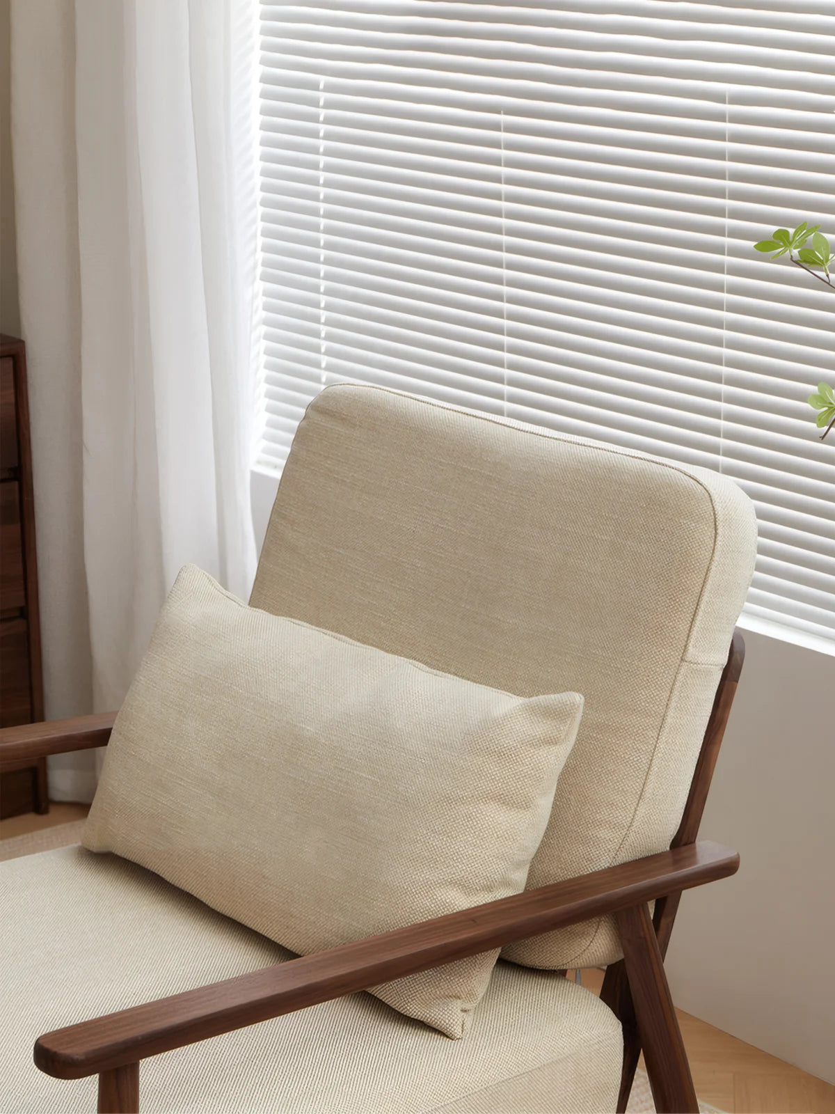 Walnutry Alden Armchair back cushion detail showing fabric upholstery, lumbar pillow, slim walnut arms, and relaxed mid-century inspired seating profile