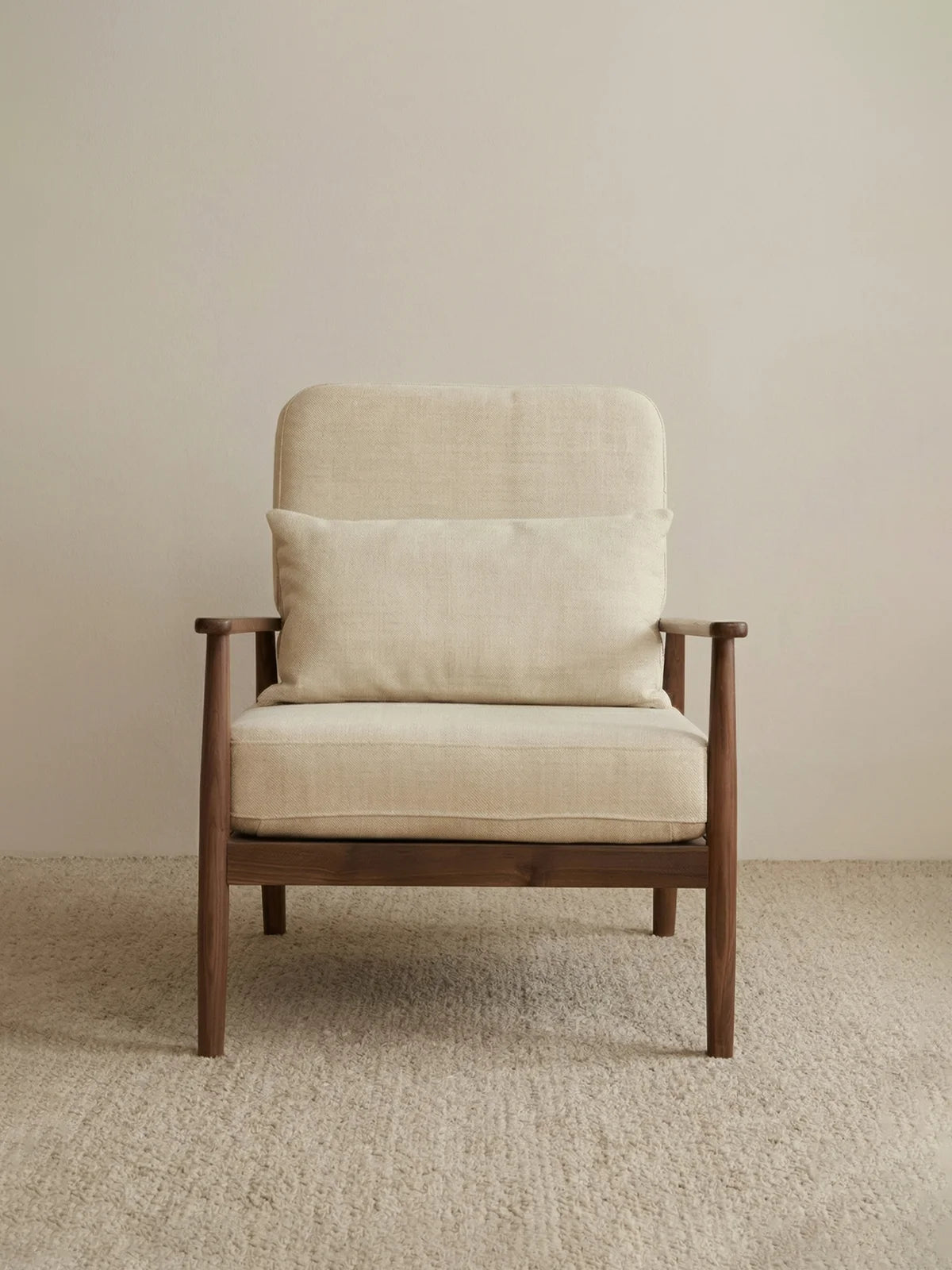 Walnutry Alden Armchair front view with neutral fabric cushions, lumbar pillow, walnut frame, and balanced proportions for living room or bedroom placement