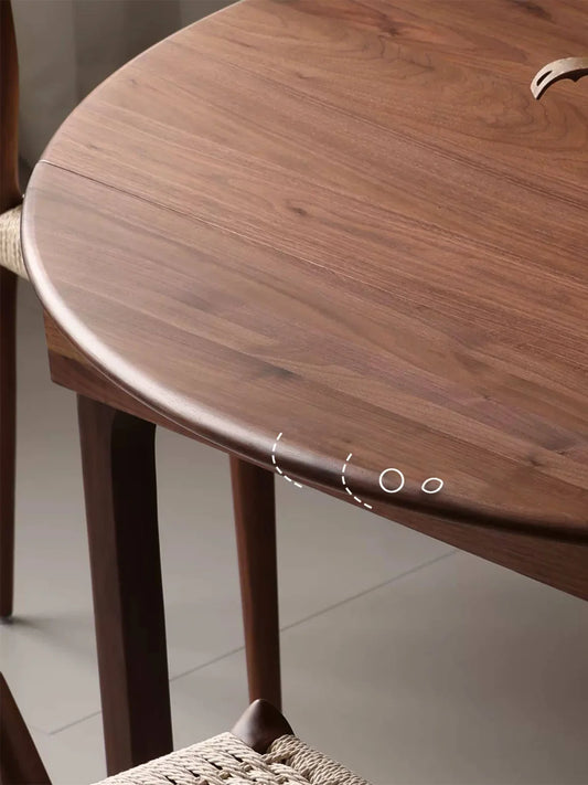 Close-up of the walnut tabletop edge, highlighting the rounded profile, extension seam, and natural wood grain.