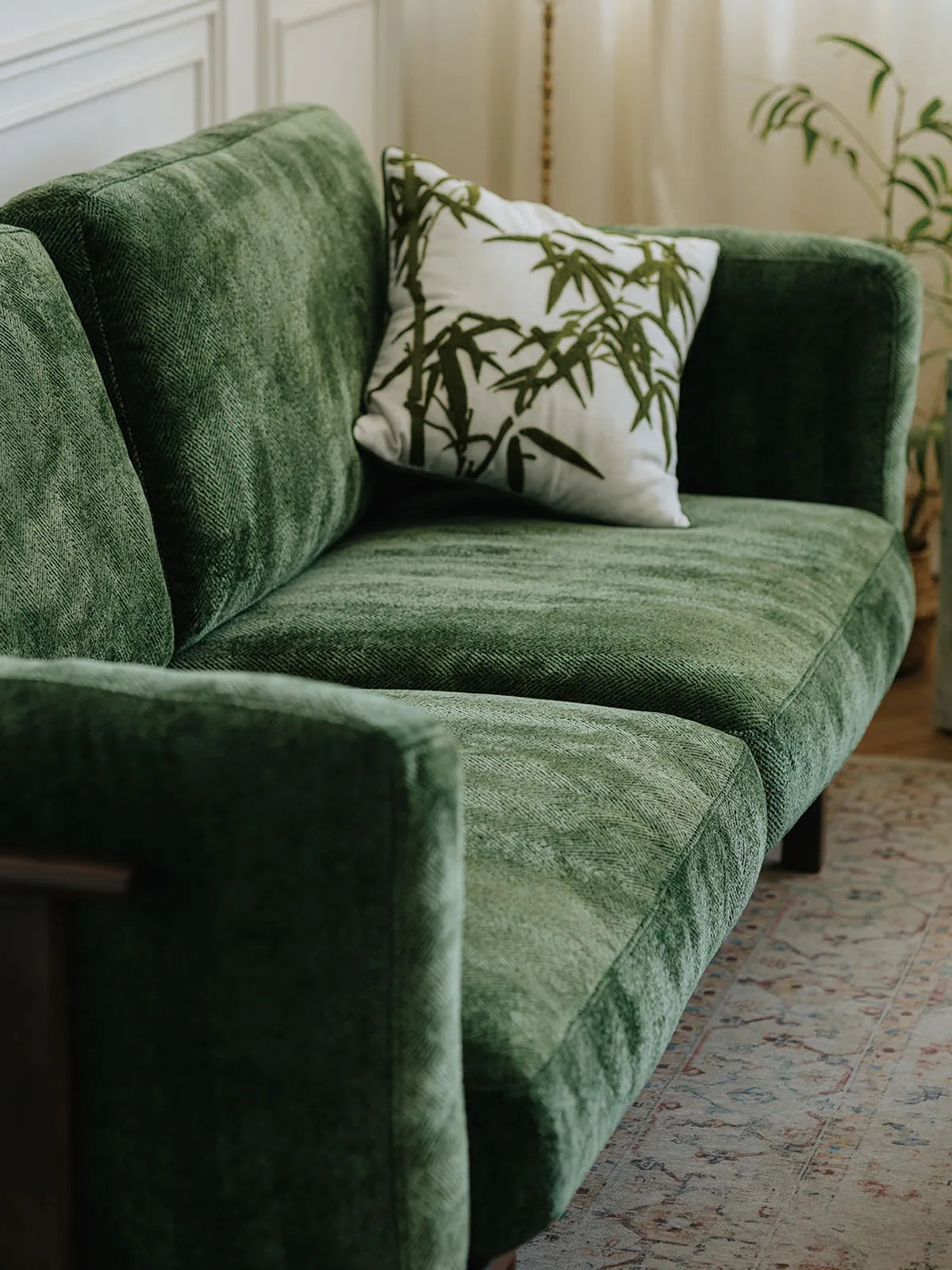 Close-up of Alden Ridge sofa seat and back cushions in green velvet with a decorative bamboo pillow