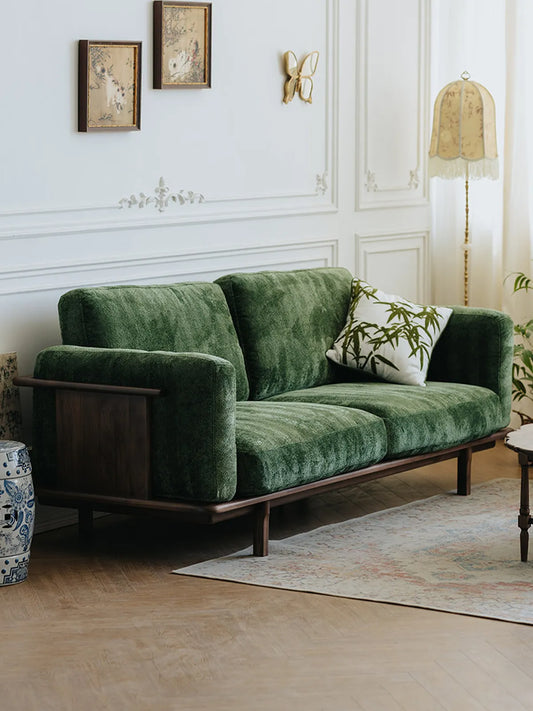 Alden Ridge sofa in green velvet upholstery, three-quarter view showing walnut frame and arm panel in a classic interior