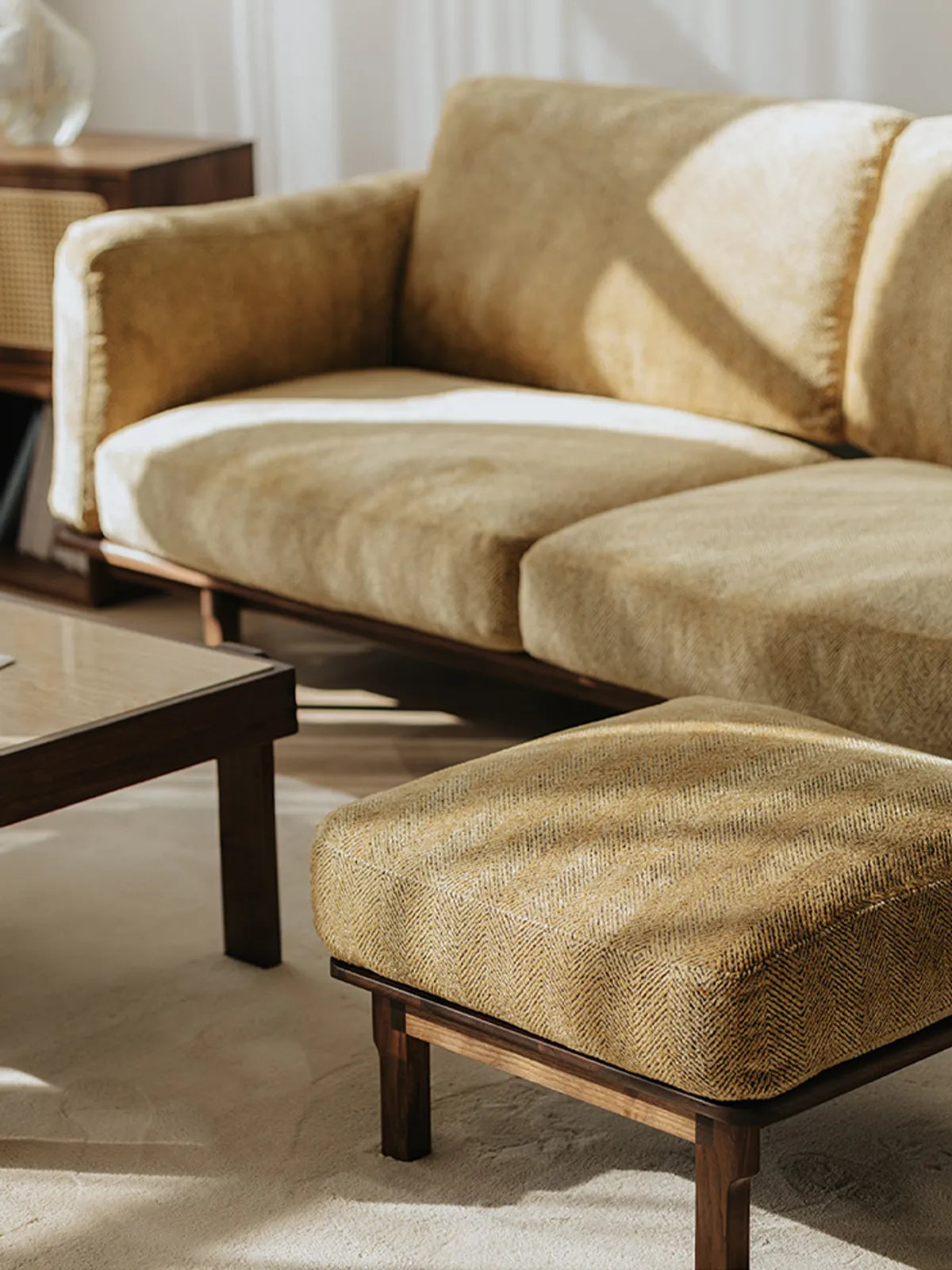 Close-up of Alden Ridge sofa in wheat herringbone fabric with matching ottoman and walnut coffee table in sunlit room