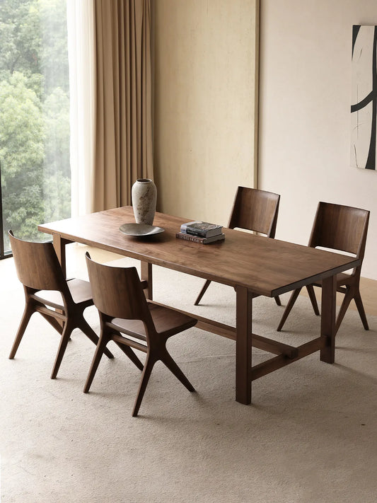 Arlen Dining Chairs arranged around a walnut dining table in a warm dining room setting.
