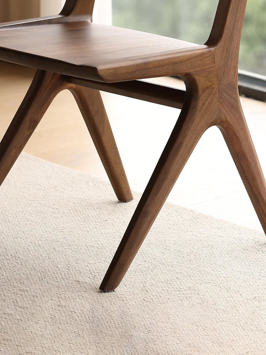 Close-up of the Arlen Dining Chair leg joinery and natural walnut wood finish.