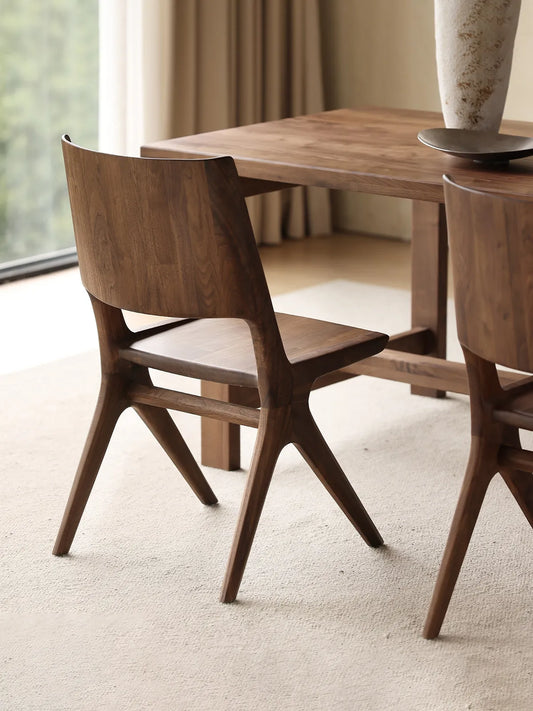 Rear angle view of the Arlen Dining Chair showing the curved backrest and walnut grain detail.
