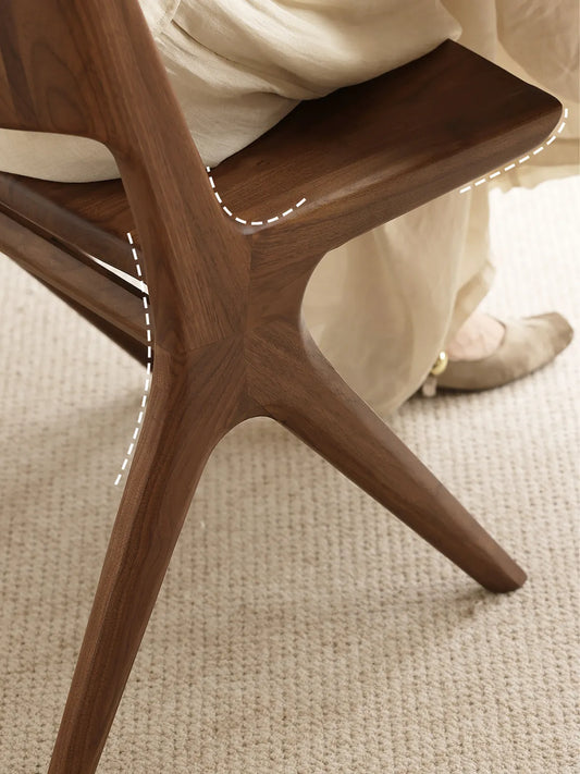Close-up of the Arlen Dining Chair contoured seat surface in solid walnut.