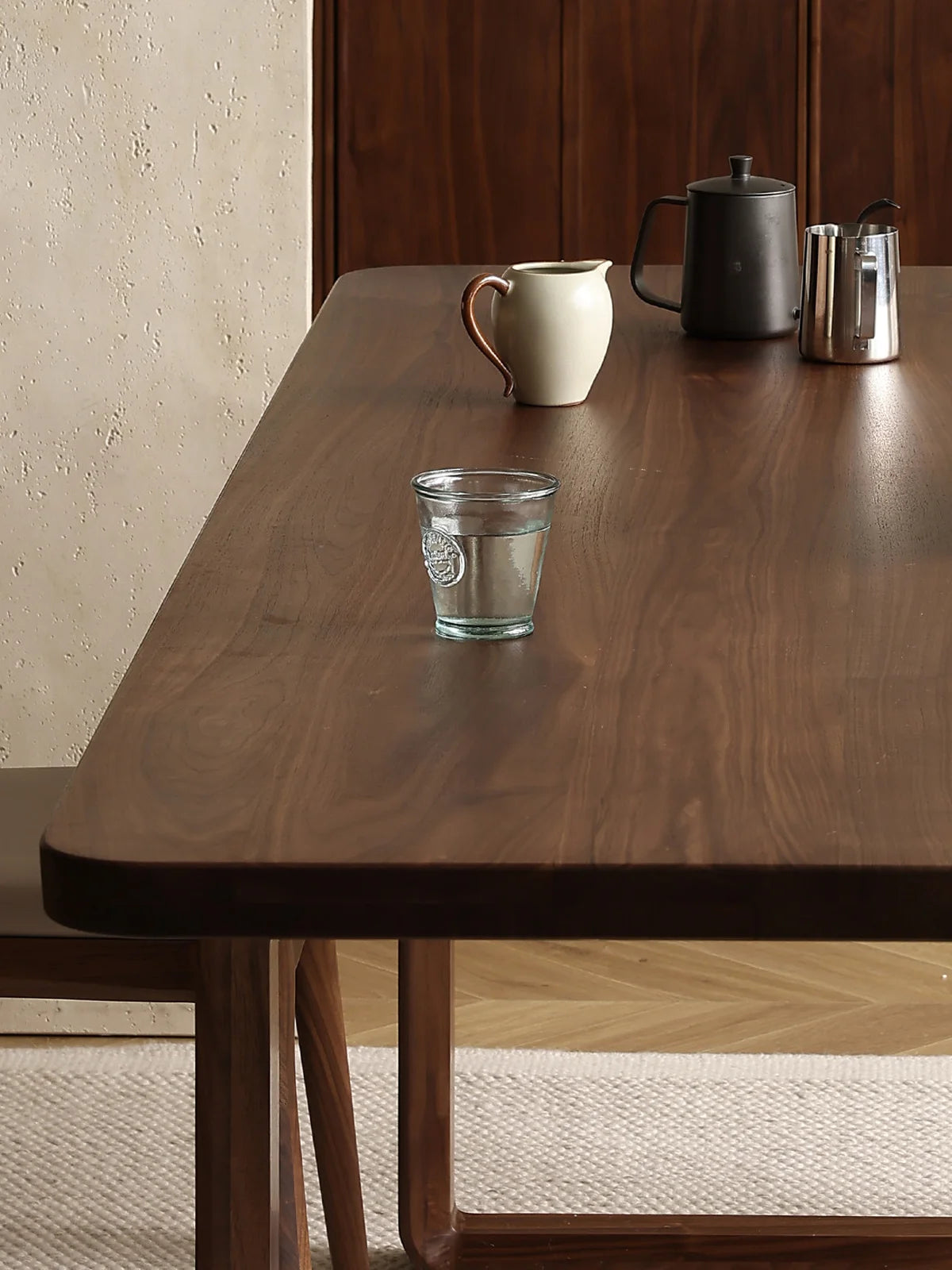 Front view of the Auren dark wood dining table with rounded rectangle top and continuous loop legs in solid American walnut.