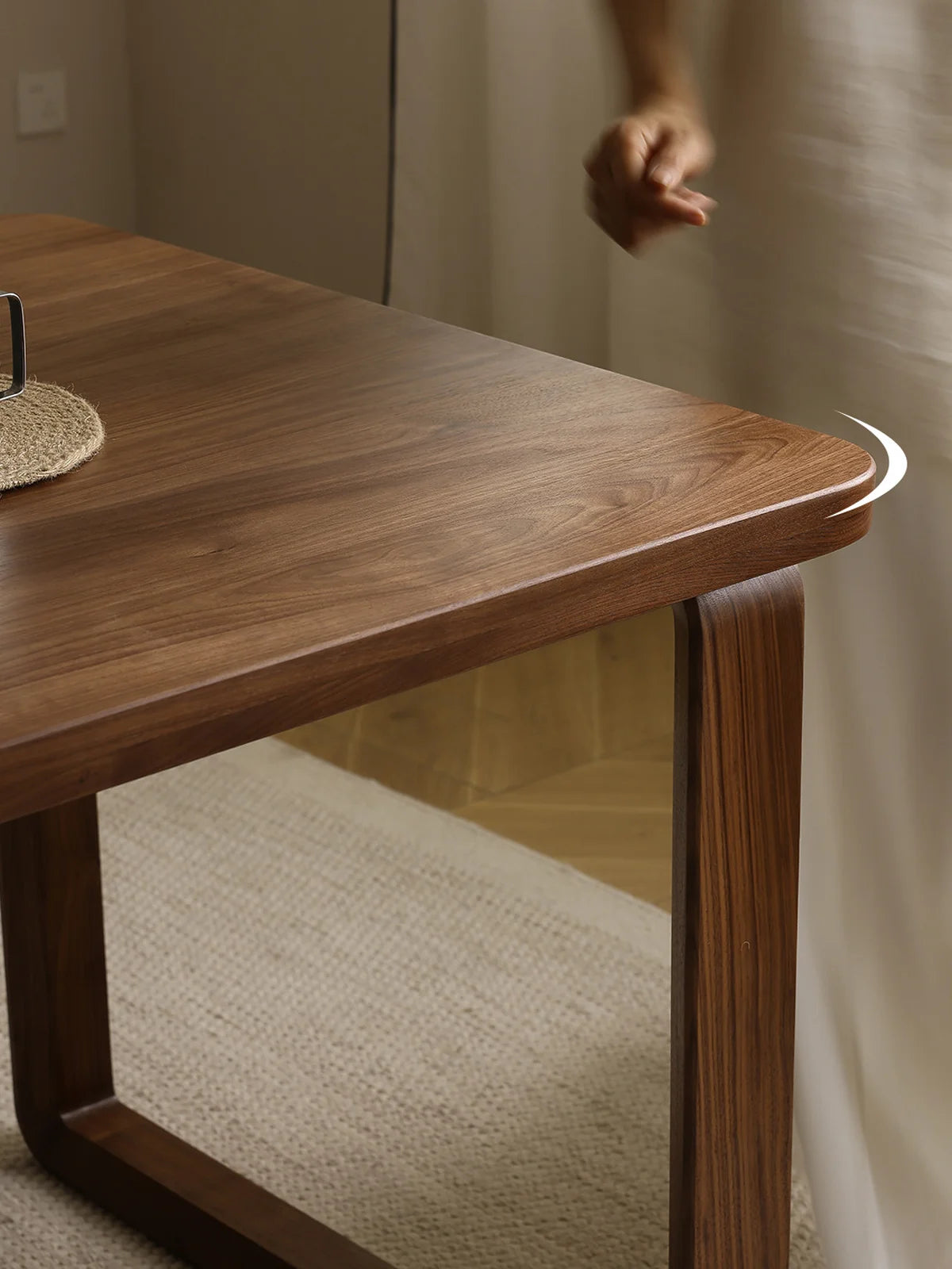 Close-up of the rounded corner and softly curved leg of the Auren Dining Table in solid American walnut by Walnutry.