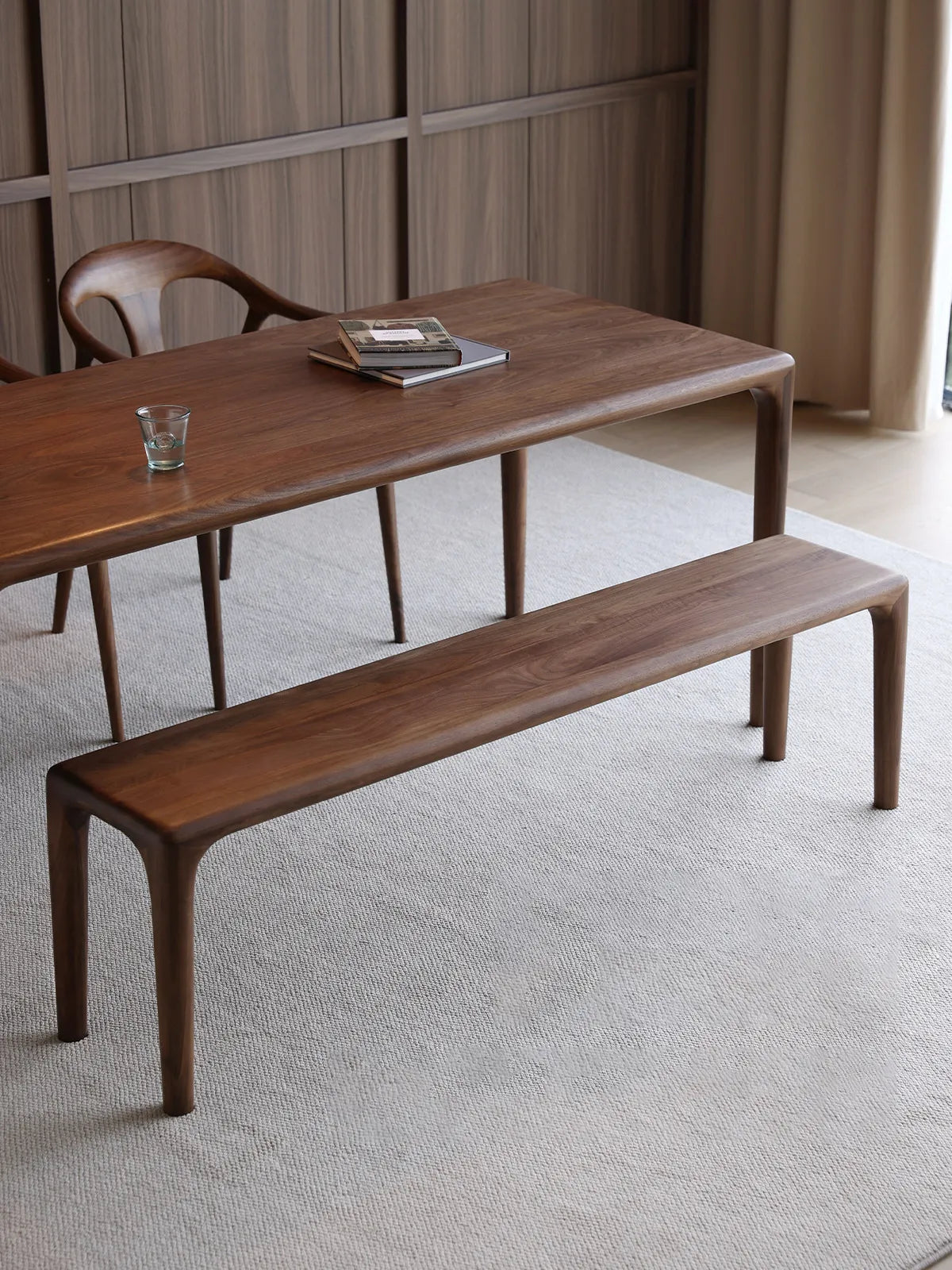 Front view of the Auren Walnut Bench in solid walnut, highlighting its minimalist profile, rounded corners, and seamless leg-to-top transition.