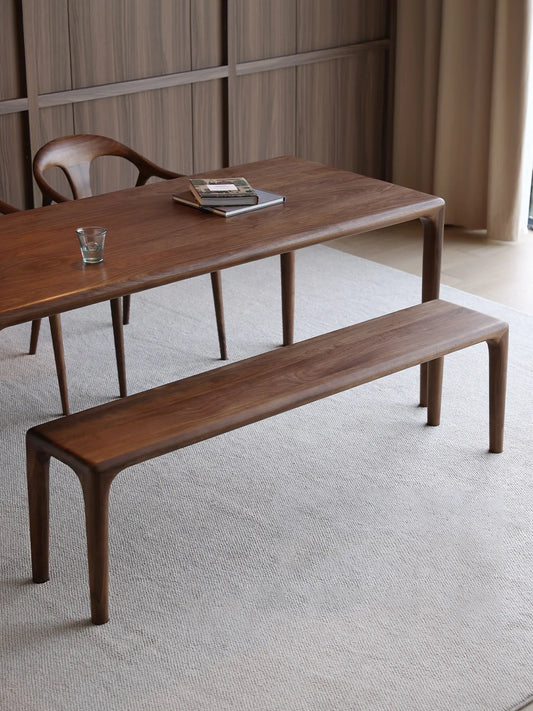 Front view of the Auren Walnut Bench in solid walnut, highlighting its minimalist profile, rounded corners, and seamless leg-to-top transition.