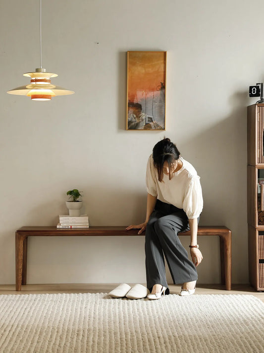 Auren Walnut Bench styled in a minimalist living room, used as a long solid walnut bench against the wall beneath warm ambient lighting.