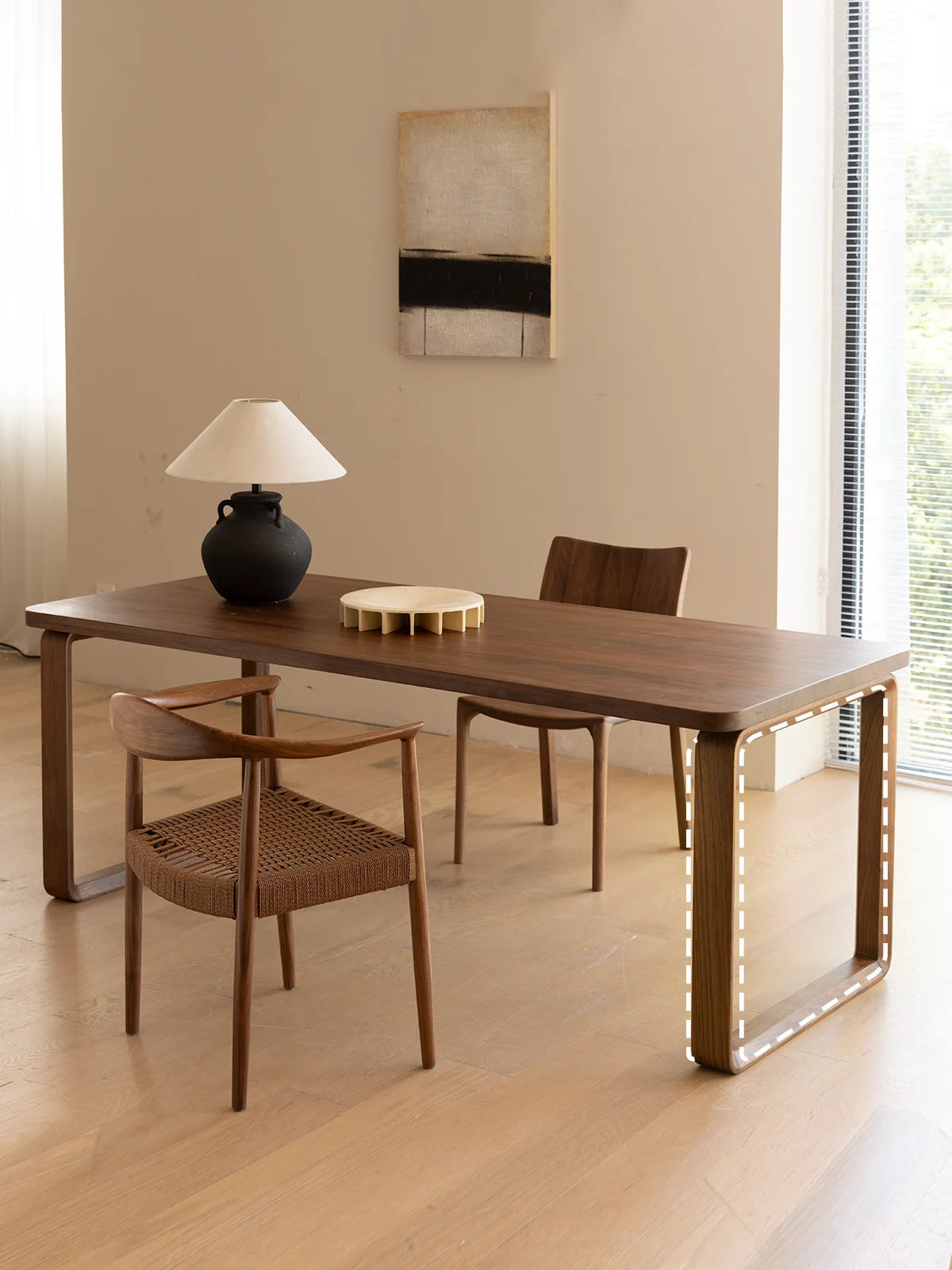 Detail of the Auren walnut mid century modern dining table leg, showing the sculptural continuous rectangular loop form.