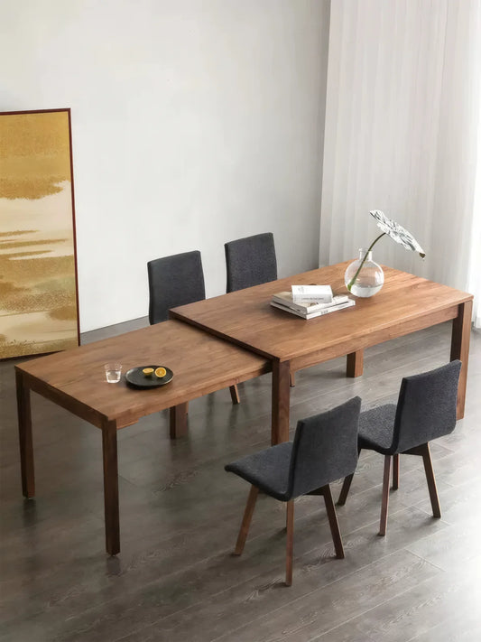 Overhead view of the space-saving walnut dining table extended to seat more guests with chairs around it