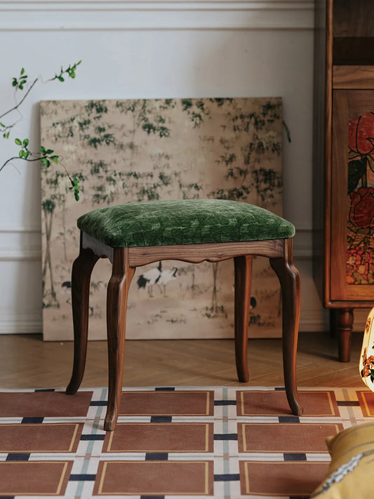 A full frontal view of The Bourbon Vanity Stool featuring its scalloped wooden apron and traditional French-style legs.