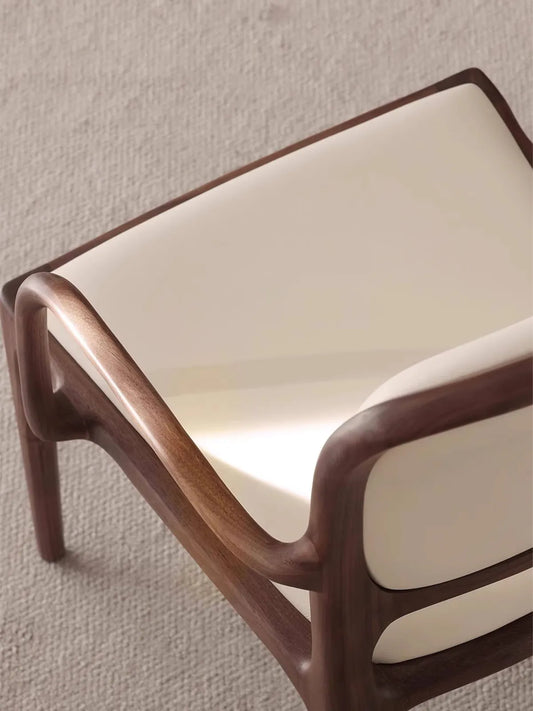 Close-up of the Cael arm chair walnut frame showing rich natural grain and zero-VOC hard wax oil finish.