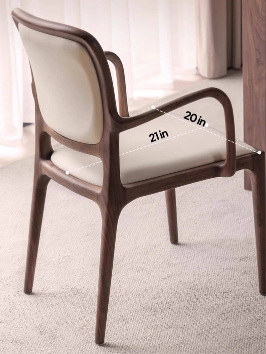 Three-quarter angle of the Cael dining arm chair highlighting the organic modern silhouette and cream upholstery.