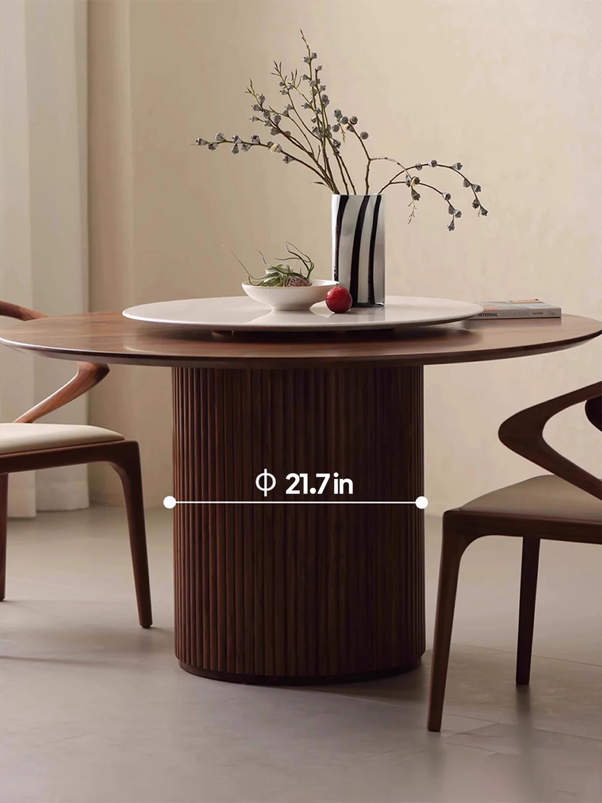 Front angle of the round walnut dining table highlighting the fluted pillar pedestal diameter beneath the top.