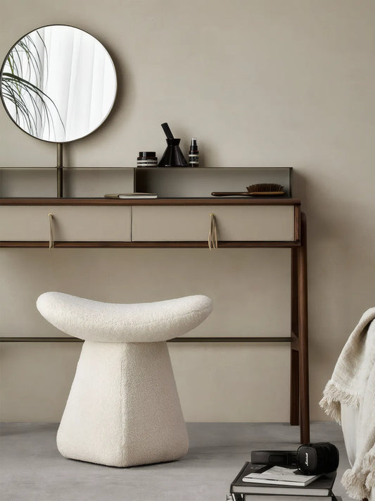 Front view of the Walnutry Cumberland mushroom stool featuring solid black walnut legs and cream bouclé upholstery, styled as a luxury vanity stool with a round mirror.