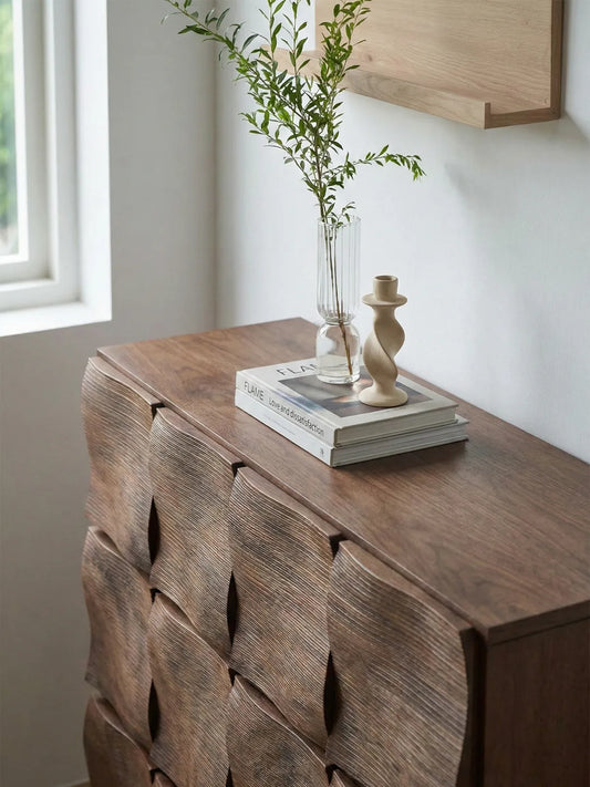 Top surface view of Walnutry Cumberland chest showing smooth solid walnut grain, styled with modern art books and organic decor.