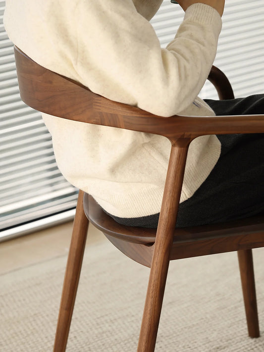 close-up of the curved walnut backrest and arm rail with a seated user