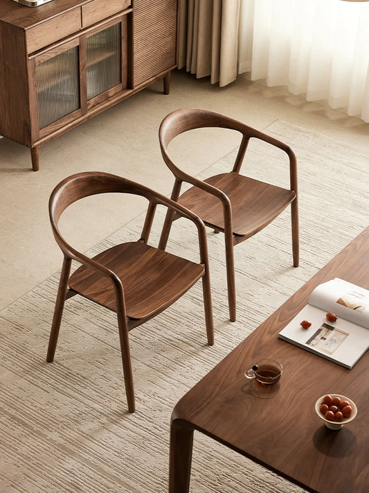 pair of curved back walnut dining chairs in a soft neutral living and dining setting