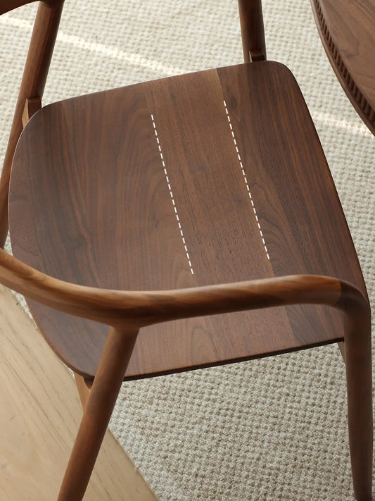 top-down detail of the solid walnut seat with visible grain and softly rounded corners
