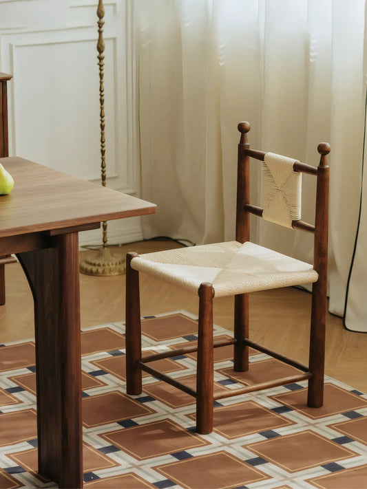 Daren woven rush chair paired with a solid walnut dining table in a styled room setting