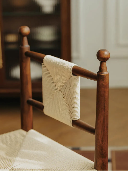 Rear detail of the Daren chair showing woven cord backrest panel and walnut finial posts