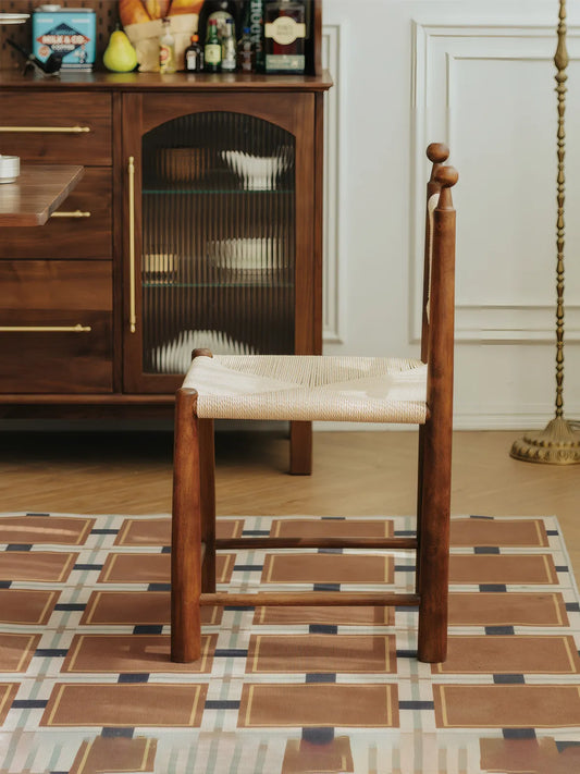 Side profile of the Daren solid walnut dining chair showing stretcher base and woven seat