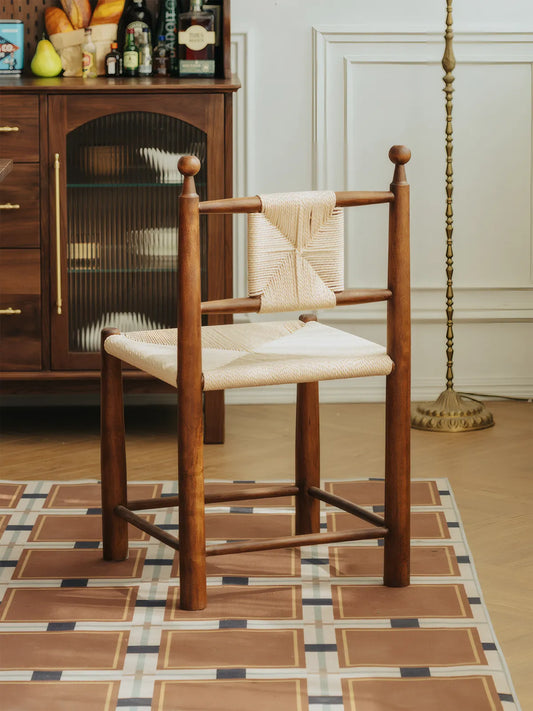 Daren walnut dining chair with woven paper cord seat, three-quarter front view in styled dining room